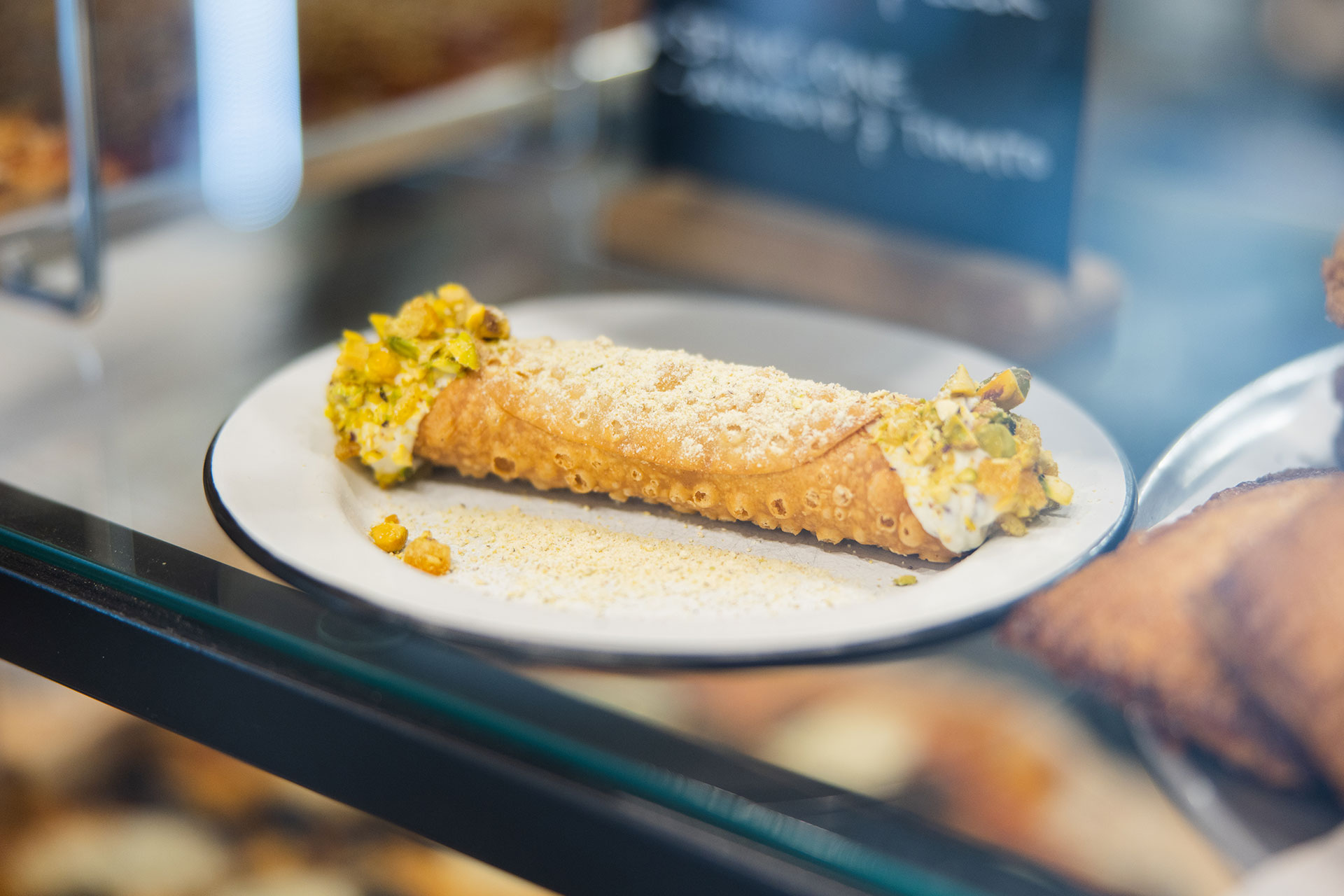 a cannoli in the pastry case at pizza thief