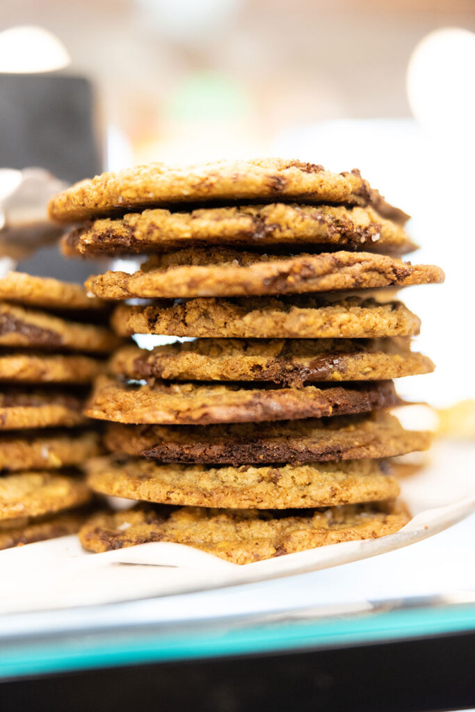a stack of chocolate chip cookies in the pastry case at pizza thief